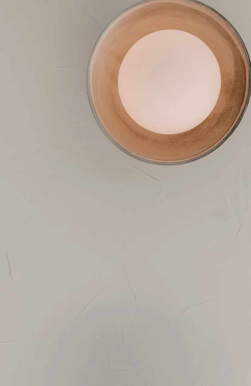 The rendered reception wall with a lit copper sconce